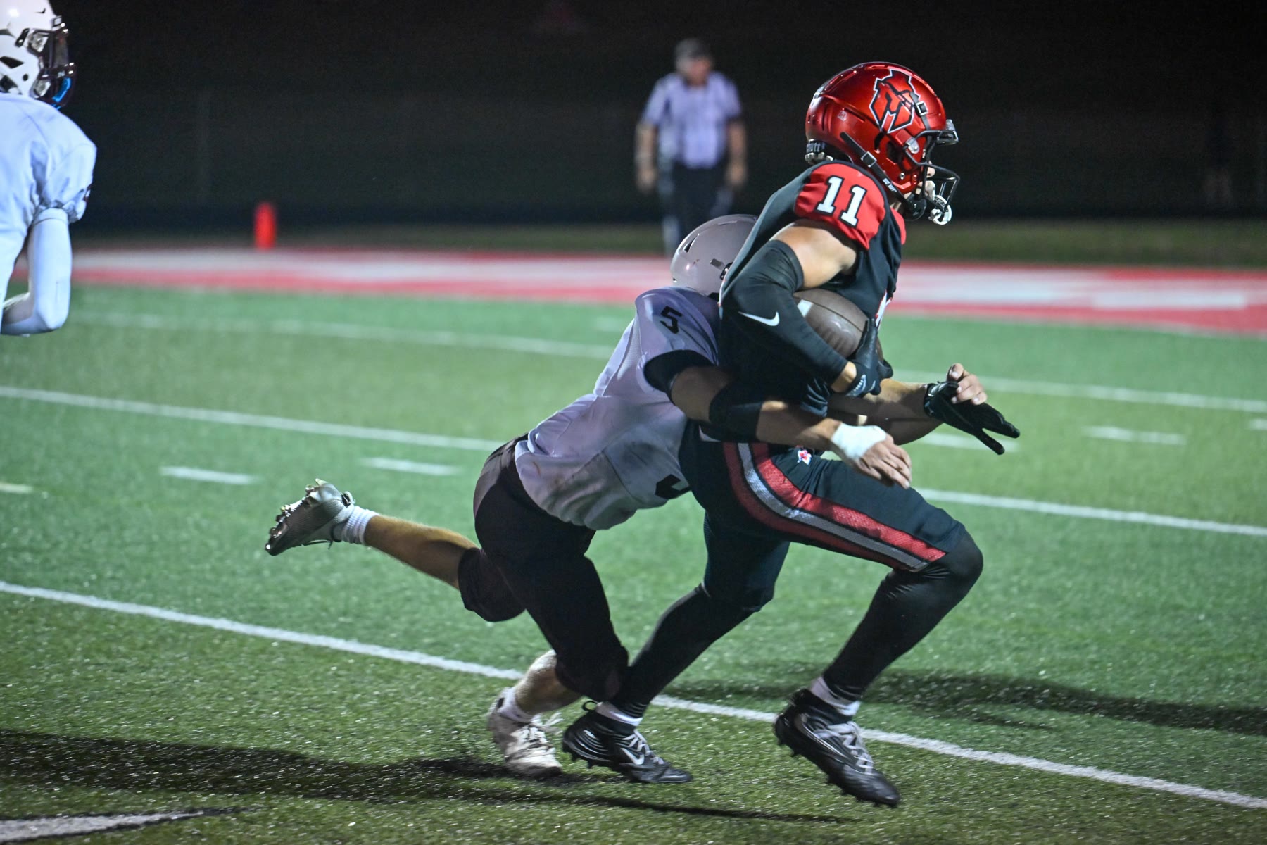 Skyler Blackburn is wrapped up by Menominee’s Caleb Barstow. Blackburn led Marquette with eight catches.