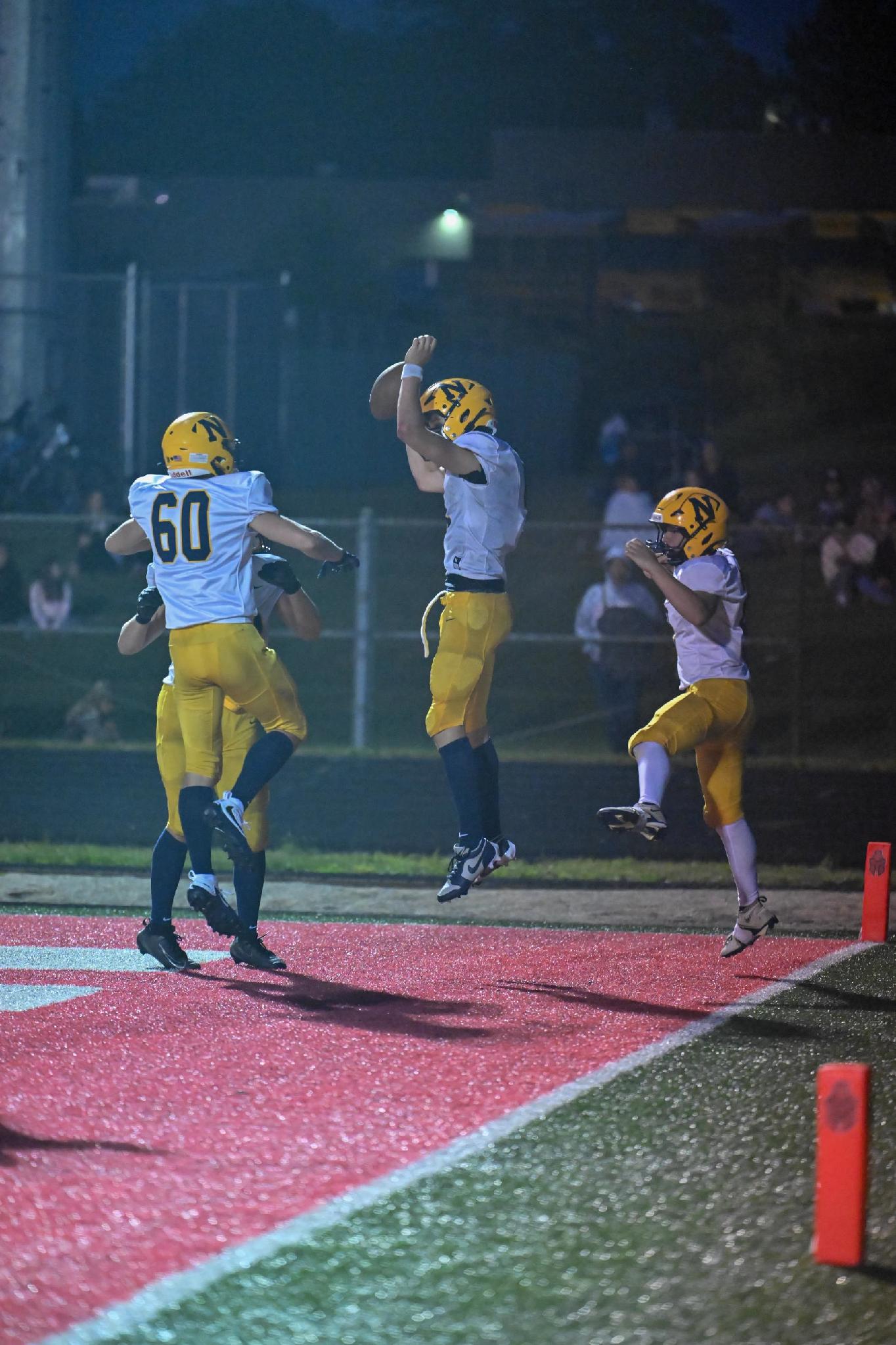 Negaunee players celebrate in the end zone after Kyle Waterman’s 13-yard touchdown run early in the fourth quarter put the Miners ahead 30-14.
