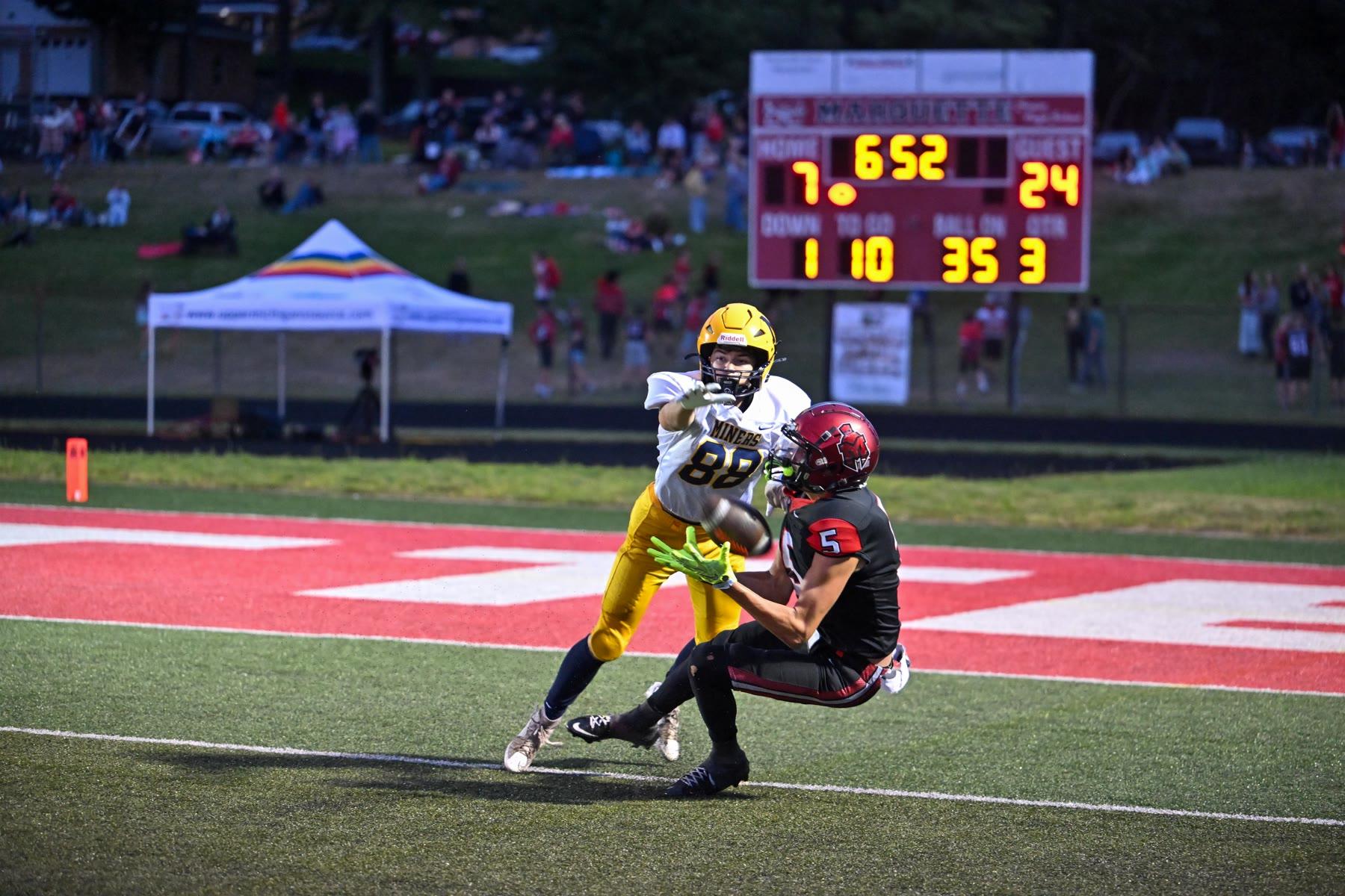 Marquette’s Brody Clements (5) and Negaunee’s Max Frustaglio (88) go up for a pass in the third quarter.