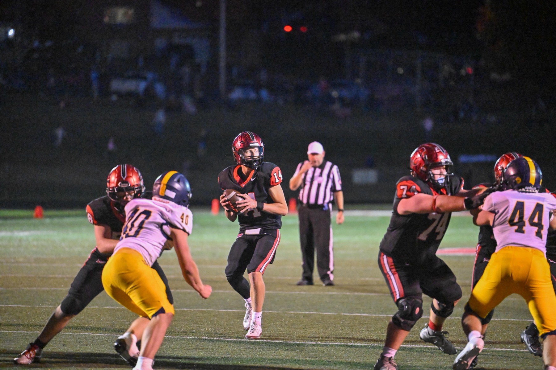 Winston Leonard (14) looks downfield from the pocket as Ayden Plantenga (74) blocks. Leonard threw four touchdown passes.